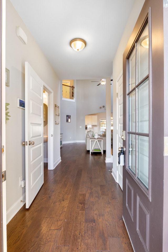 foyer with ceiling fan, baseboards, and dark wood finished floors