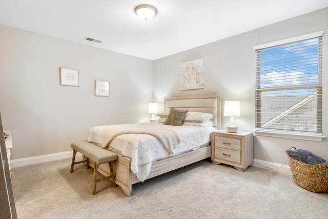 bedroom with light carpet, visible vents, and baseboards