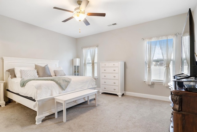 bedroom with baseboards, ceiling fan, visible vents, and light colored carpet