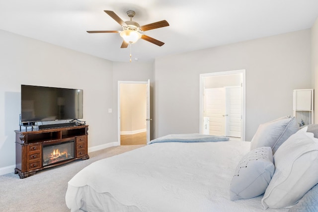 bedroom featuring connected bathroom, light colored carpet, ceiling fan, and baseboards