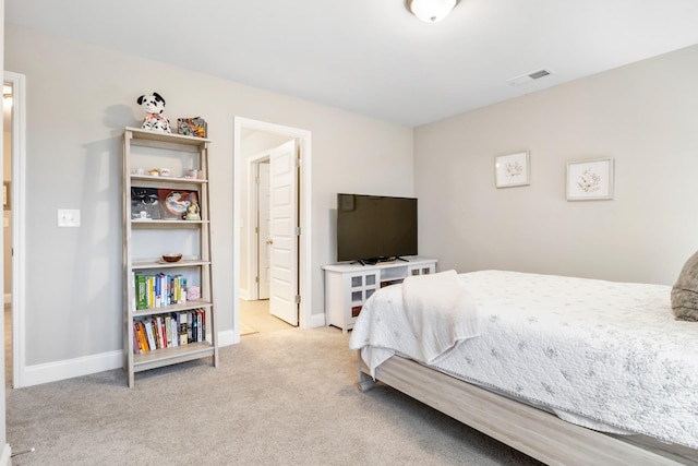 bedroom featuring visible vents, ensuite bath, light carpet, and baseboards