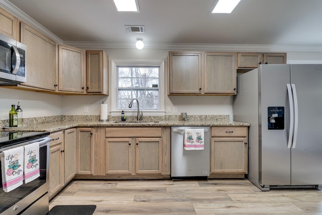 kitchen with light brown cabinetry, appliances with stainless steel finishes, a sink, and crown molding