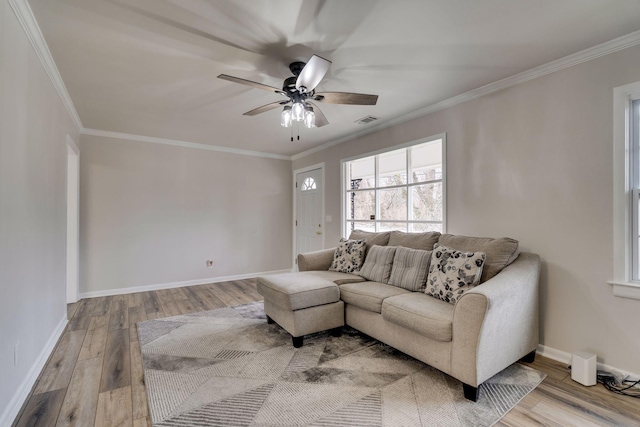 living area with ornamental molding, wood finished floors, and visible vents