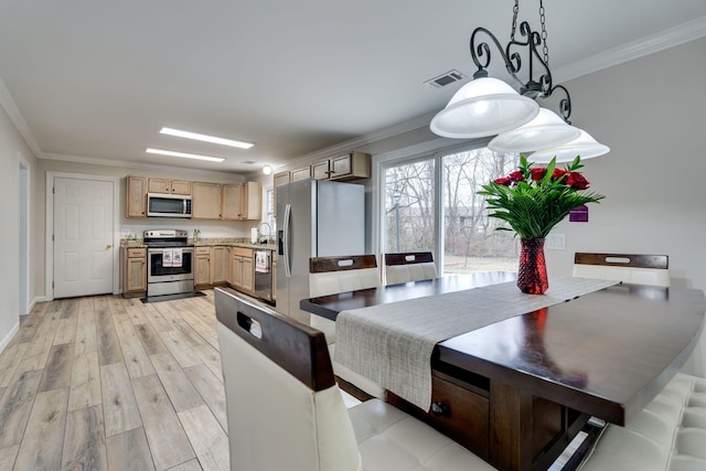 kitchen with pendant lighting, crown molding, visible vents, appliances with stainless steel finishes, and light brown cabinets