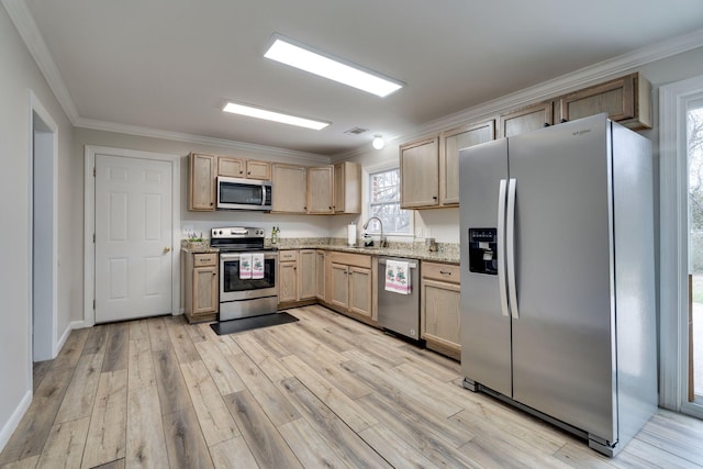 kitchen featuring light stone counters, light brown cabinets, light wood-style flooring, stainless steel appliances, and crown molding