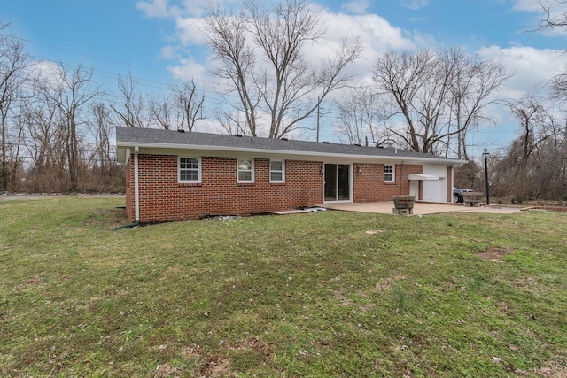 back of house with a garage, brick siding, a lawn, and a patio