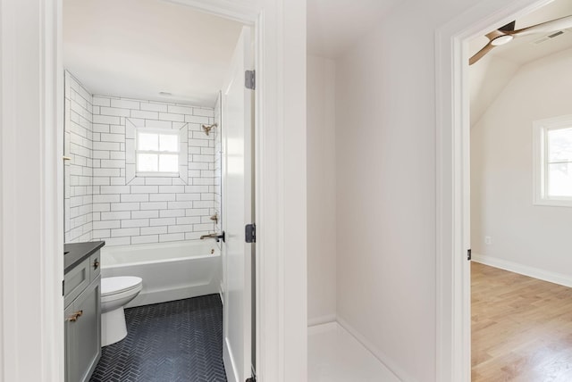 bathroom with baseboards, visible vents, toilet, vanity, and shower / bathtub combination