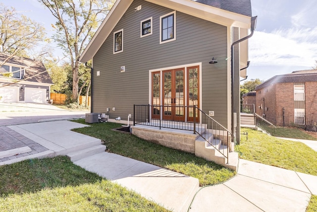 view of front of house featuring central AC unit and a front yard