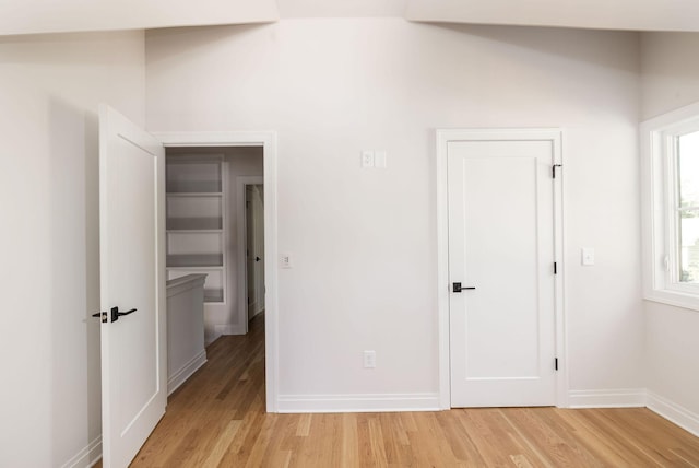 unfurnished bedroom featuring light wood-type flooring and baseboards