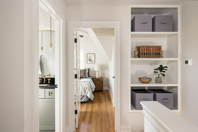 hall with a sink and wood finished floors