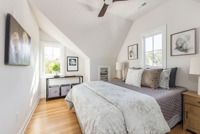 bedroom with baseboards, multiple windows, vaulted ceiling, and light wood finished floors