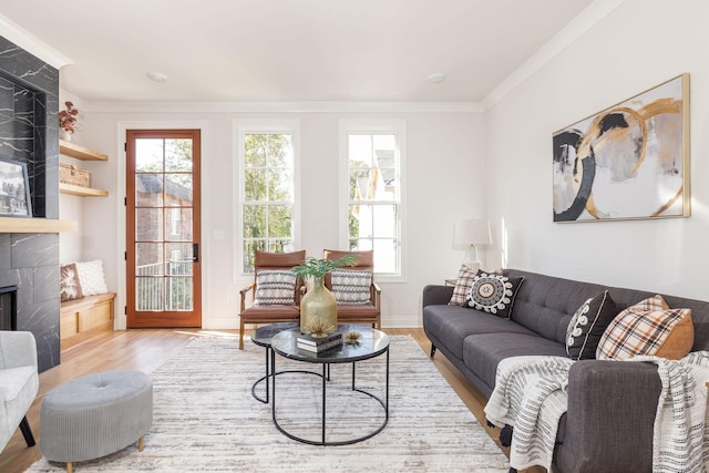 living room with ornamental molding, a fireplace, wood finished floors, and baseboards