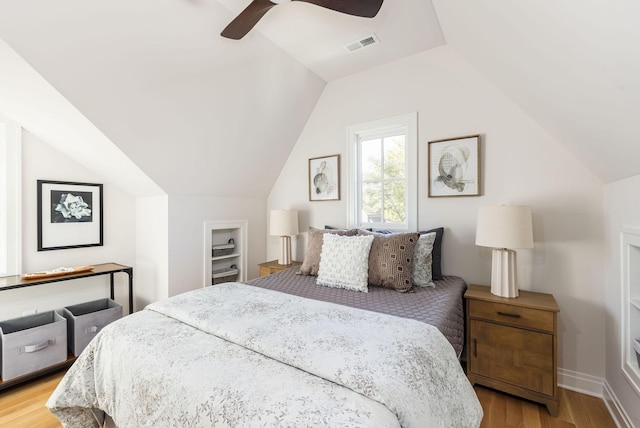 bedroom featuring baseboards, visible vents, a ceiling fan, lofted ceiling, and light wood-style flooring