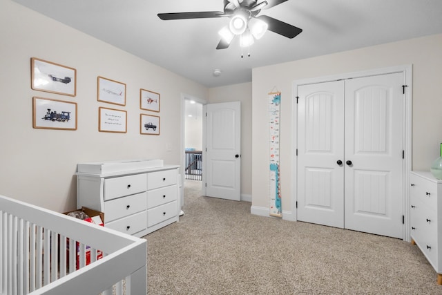 bedroom featuring light colored carpet, a closet, a ceiling fan, and baseboards