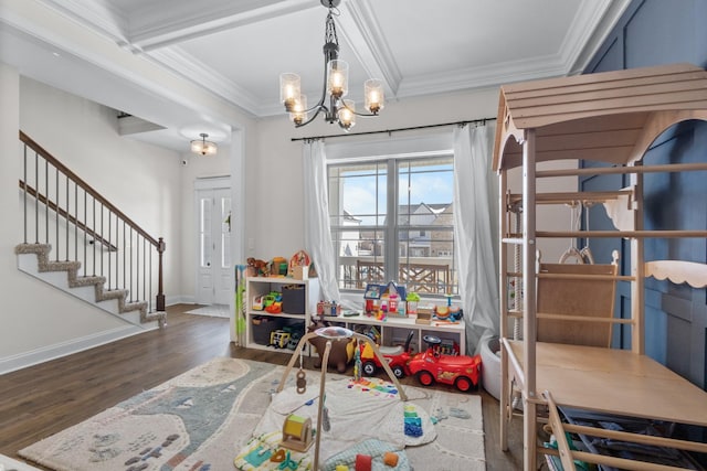 playroom with dark wood-style floors, baseboards, ornamental molding, and a chandelier