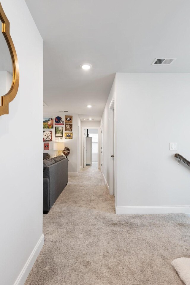 hall featuring light carpet, baseboards, visible vents, and recessed lighting