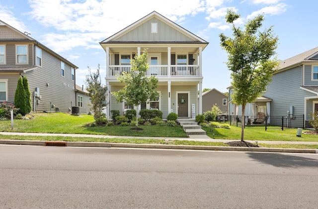 view of front of property with a balcony, covered porch, board and batten siding, and a front yard