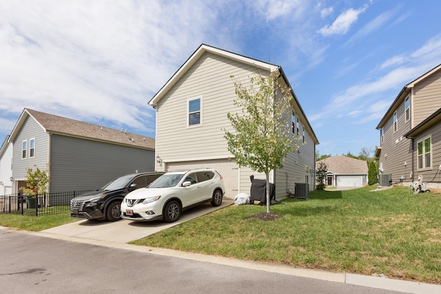 view of side of property featuring central air condition unit, driveway, a garage, and a lawn