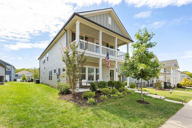 view of front of property with a balcony, central air condition unit, covered porch, a front lawn, and board and batten siding