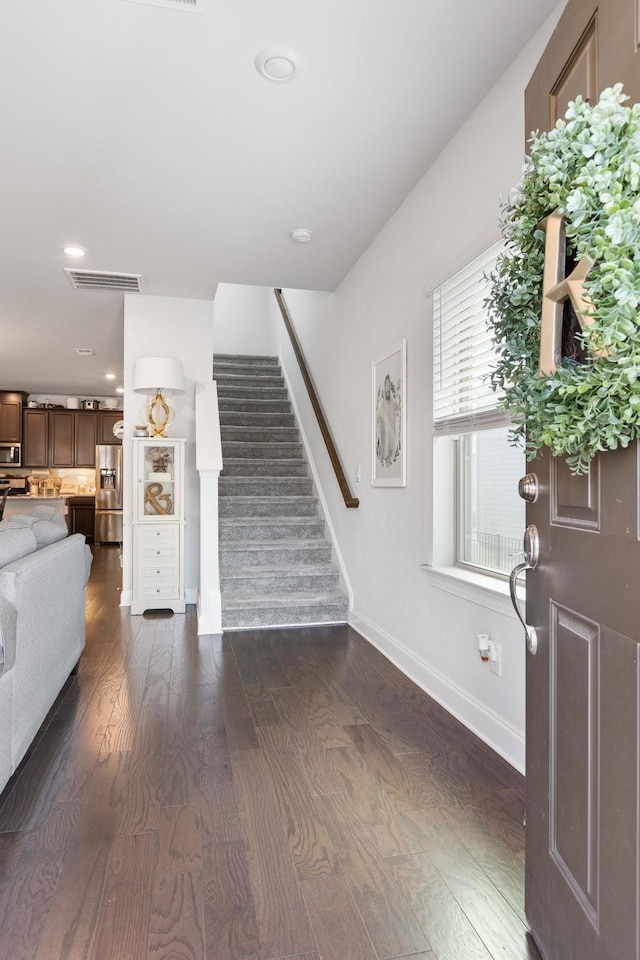 foyer entrance with recessed lighting, visible vents, stairway, dark wood-type flooring, and baseboards