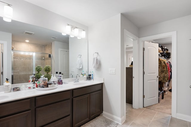 bathroom featuring a sink, visible vents, a spacious closet, tile patterned floors, and a stall shower