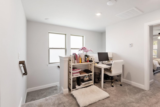 office space featuring light carpet, baseboards, and visible vents