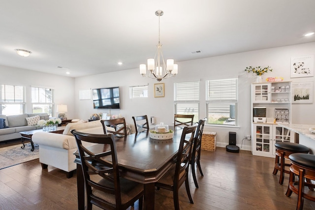 dining space with dark wood-style floors, recessed lighting, visible vents, and a notable chandelier