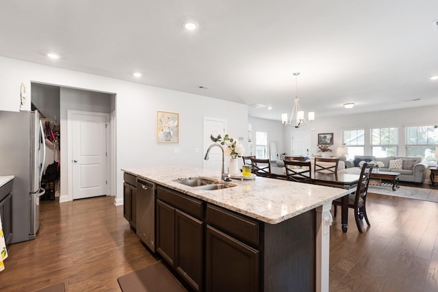 kitchen featuring a center island with sink, dark wood-style floors, open floor plan, stainless steel appliances, and a sink