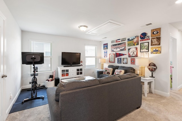 living area featuring attic access, visible vents, light carpet, and baseboards