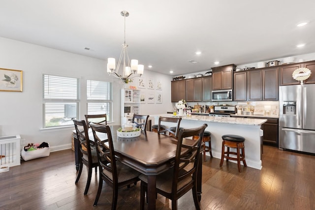 dining space featuring baseboards, recessed lighting, dark wood finished floors, and an inviting chandelier