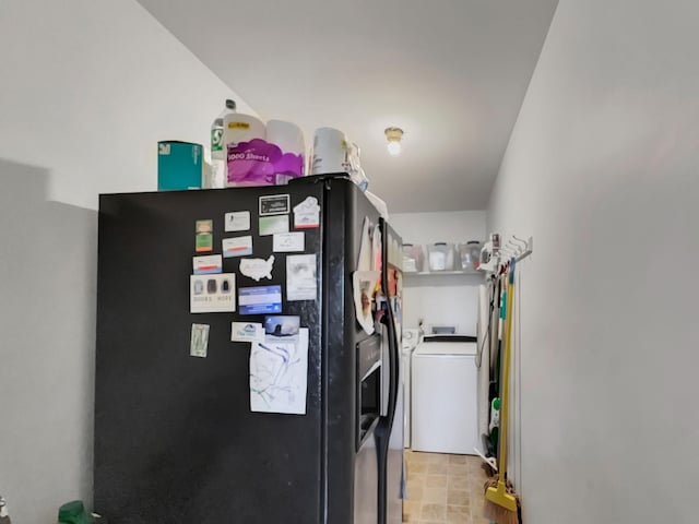 interior space featuring independent washer and dryer and black refrigerator with ice dispenser