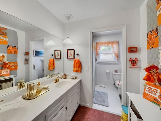 full bathroom featuring baseboards, a sink, toilet, and double vanity