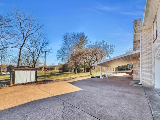 view of patio / terrace with concrete driveway and an outdoor structure