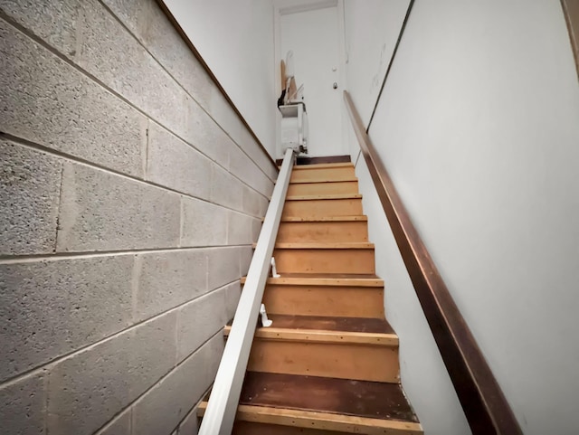 staircase featuring concrete block wall