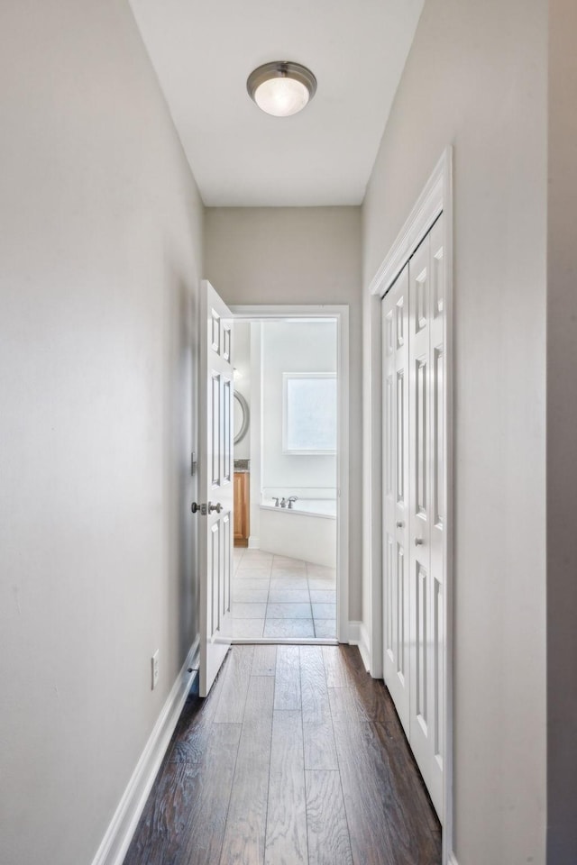 hall featuring baseboards and wood finished floors