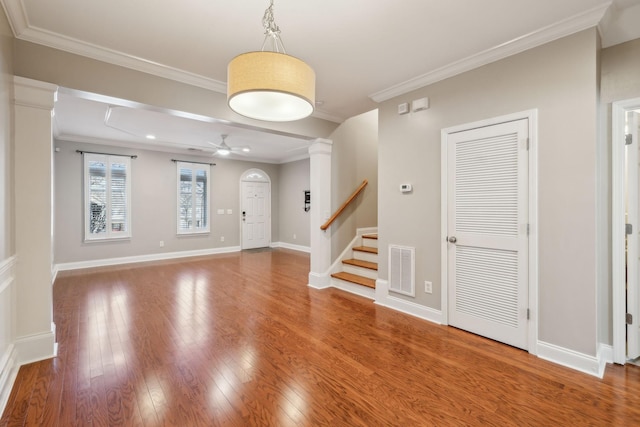 entryway with stairway, visible vents, hardwood / wood-style floors, and ornamental molding