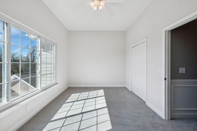 empty room with carpet, baseboards, and ceiling fan