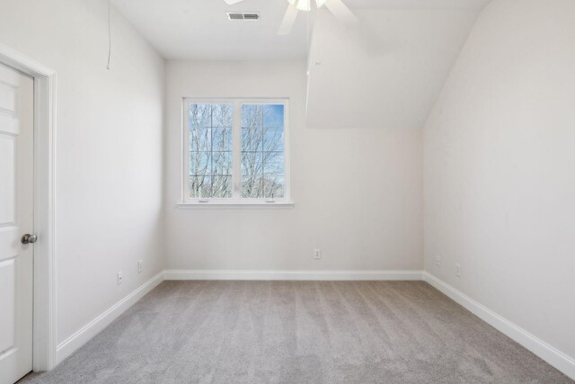 carpeted spare room featuring baseboards, visible vents, and ceiling fan