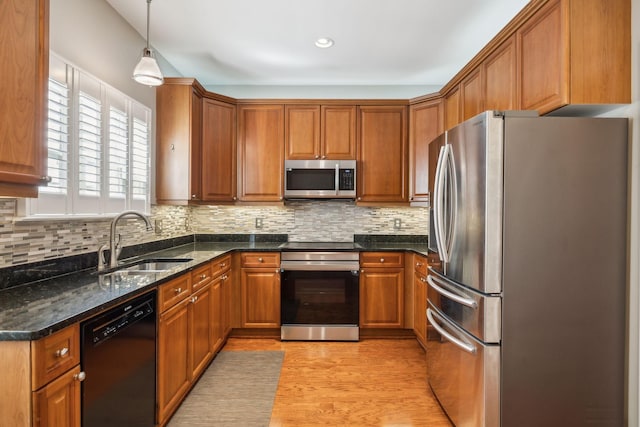 kitchen featuring appliances with stainless steel finishes, brown cabinetry, and a sink