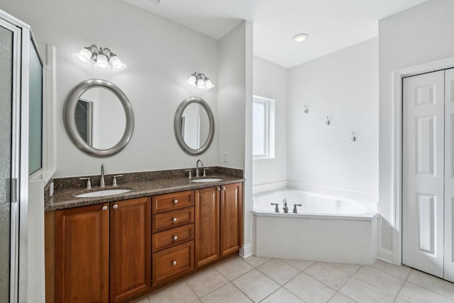 bathroom featuring double vanity, tile patterned flooring, a sink, and a bath