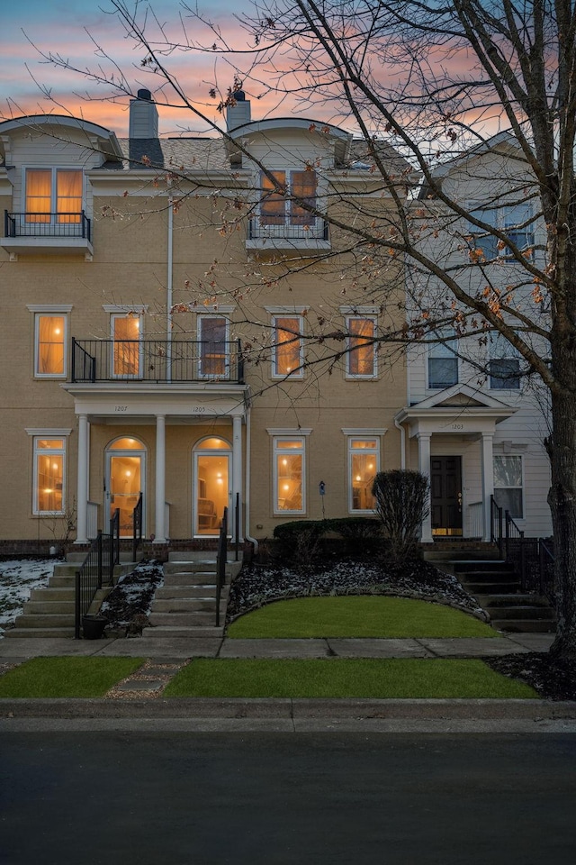 view of front of house with a chimney and a balcony