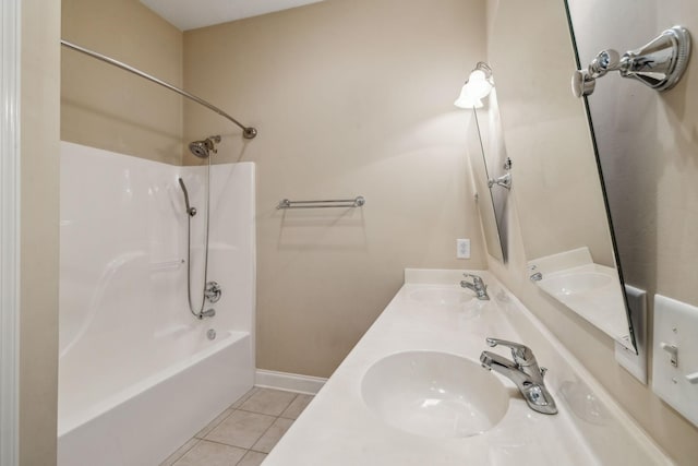 bathroom with baseboards, tub / shower combination, a sink, and tile patterned floors