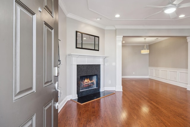 unfurnished living room with recessed lighting, wood finished floors, a ceiling fan, ornamental molding, and a tiled fireplace