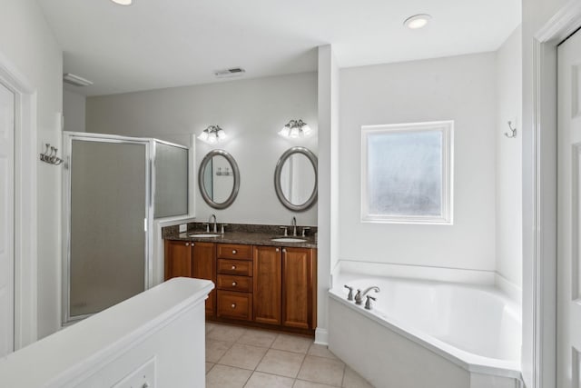 full bathroom featuring tile patterned floors, double vanity, a sink, and a bath