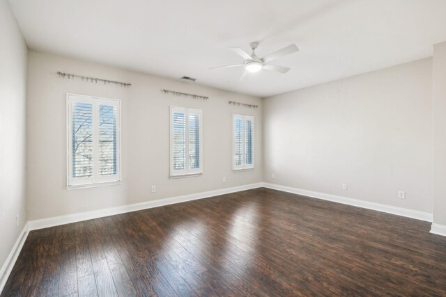 unfurnished room featuring dark wood-style floors, visible vents, ceiling fan, and baseboards