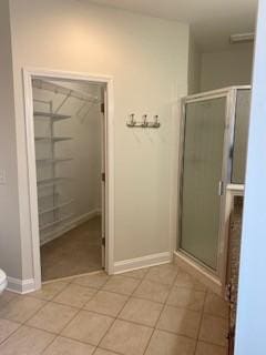 full bathroom with baseboards, a stall shower, toilet, and tile patterned floors