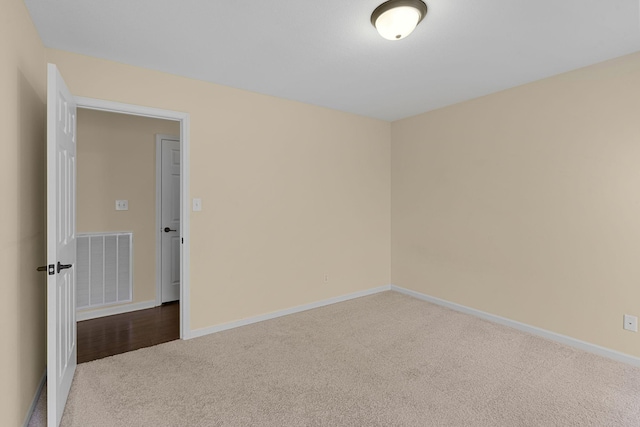 unfurnished room featuring carpet floors, visible vents, and baseboards