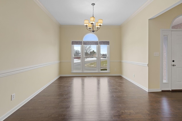 spare room with baseboards, crown molding, a chandelier, and wood finished floors