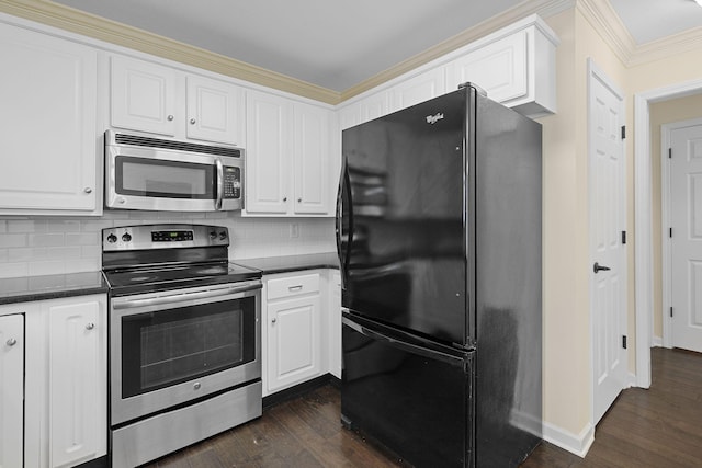 kitchen with stainless steel appliances, dark countertops, white cabinets, and dark wood-style floors