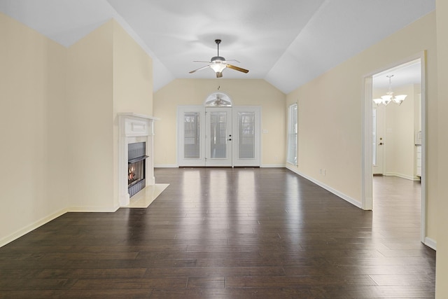 unfurnished living room with dark wood finished floors, lofted ceiling, a high end fireplace, baseboards, and ceiling fan with notable chandelier